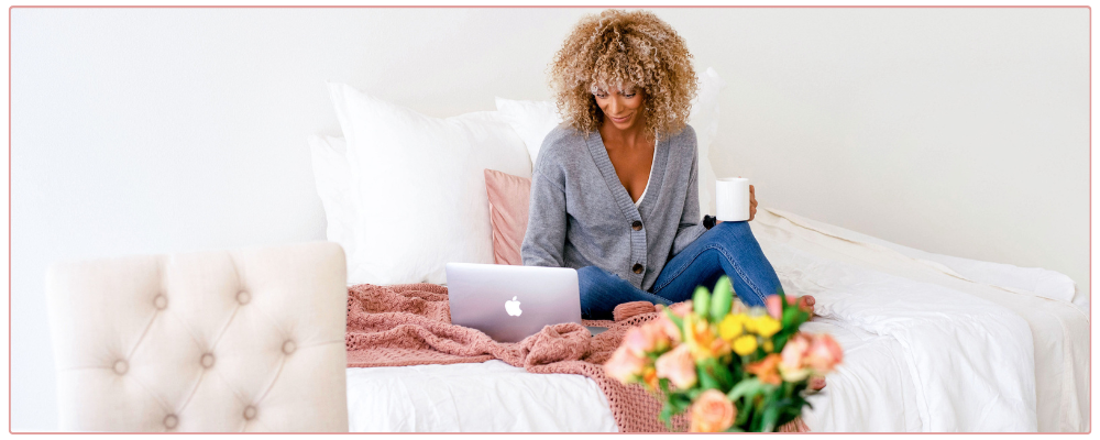 Woman working at her desk in her home office, looking at her phone